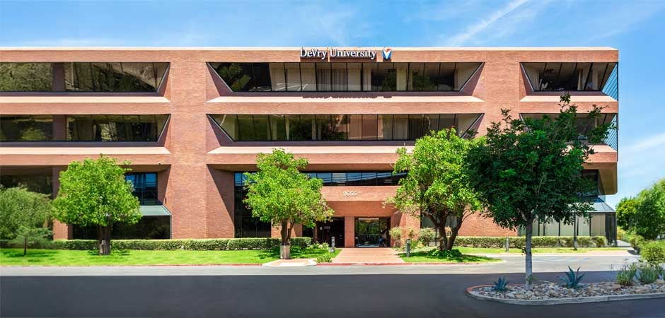 Brick campus building with entrance, landscaping, and sign reading "DeVry University"