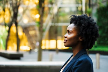 Young woman gazing thoughtfully to the right in an urban park