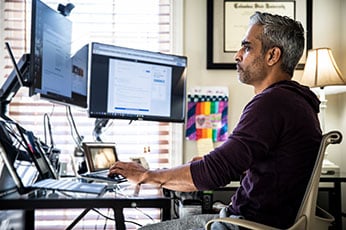 Photo of man working at computer desk