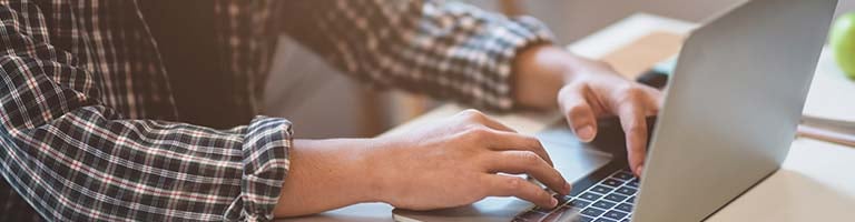 Photo of man's hands at a laptop computer