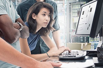 photo of office workers looking at a computer screen