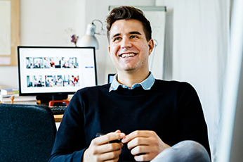man sitting in front of desk and computer