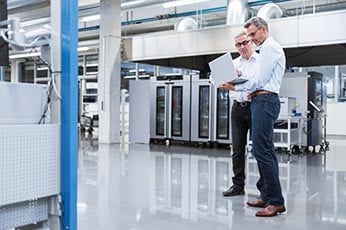 IT professionals in server room with laptop