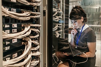 photo of woman sitting with laptop in computer room