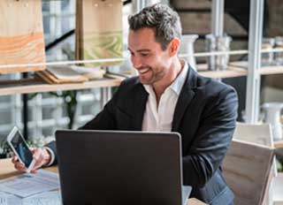 Young man smiles while reviewing the benefits of employer education partnerships.