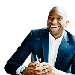 Smiling businessman in navy suit holding pen, engaged in conversation at desk