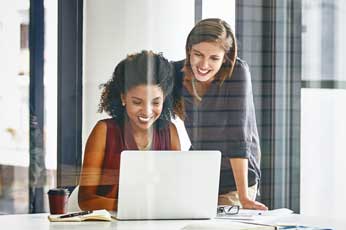 two women looking at laptop computer